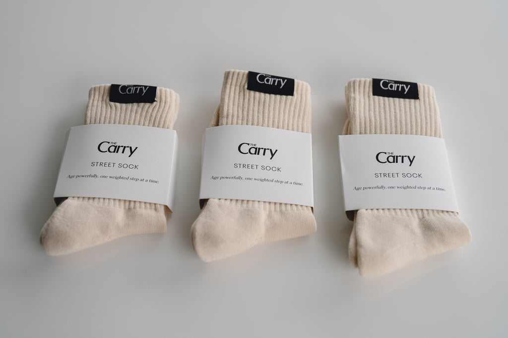 Three pairs of beige socks with 'The Carry' labels on a light gray background