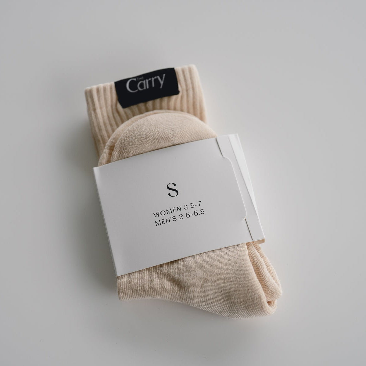 Beige socks with a visible brand label on a light gray background