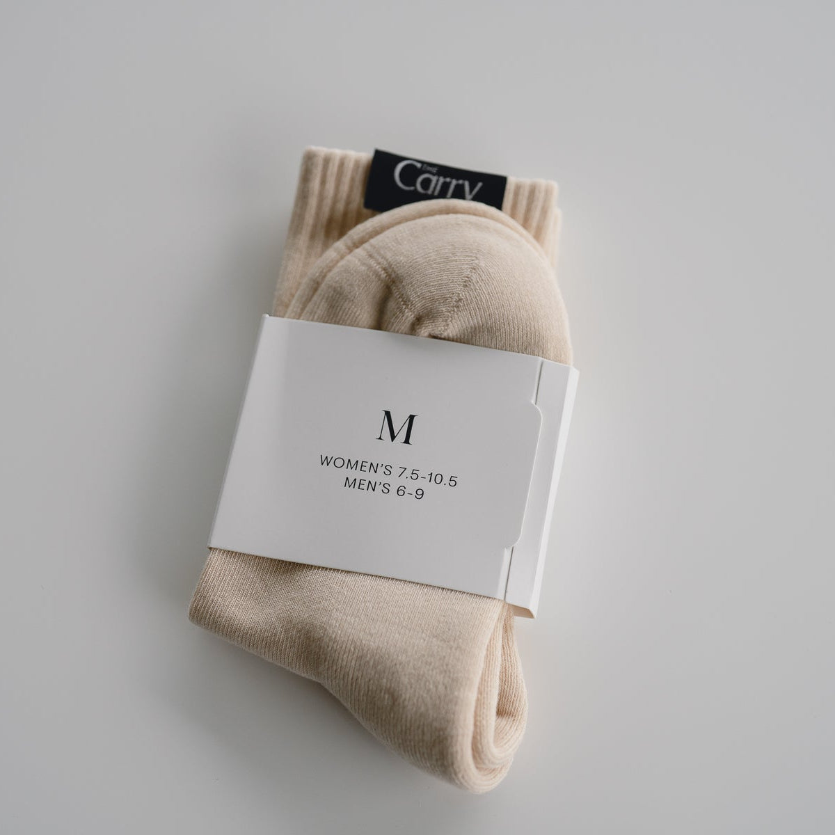 Beige socks with a white label on a gray background