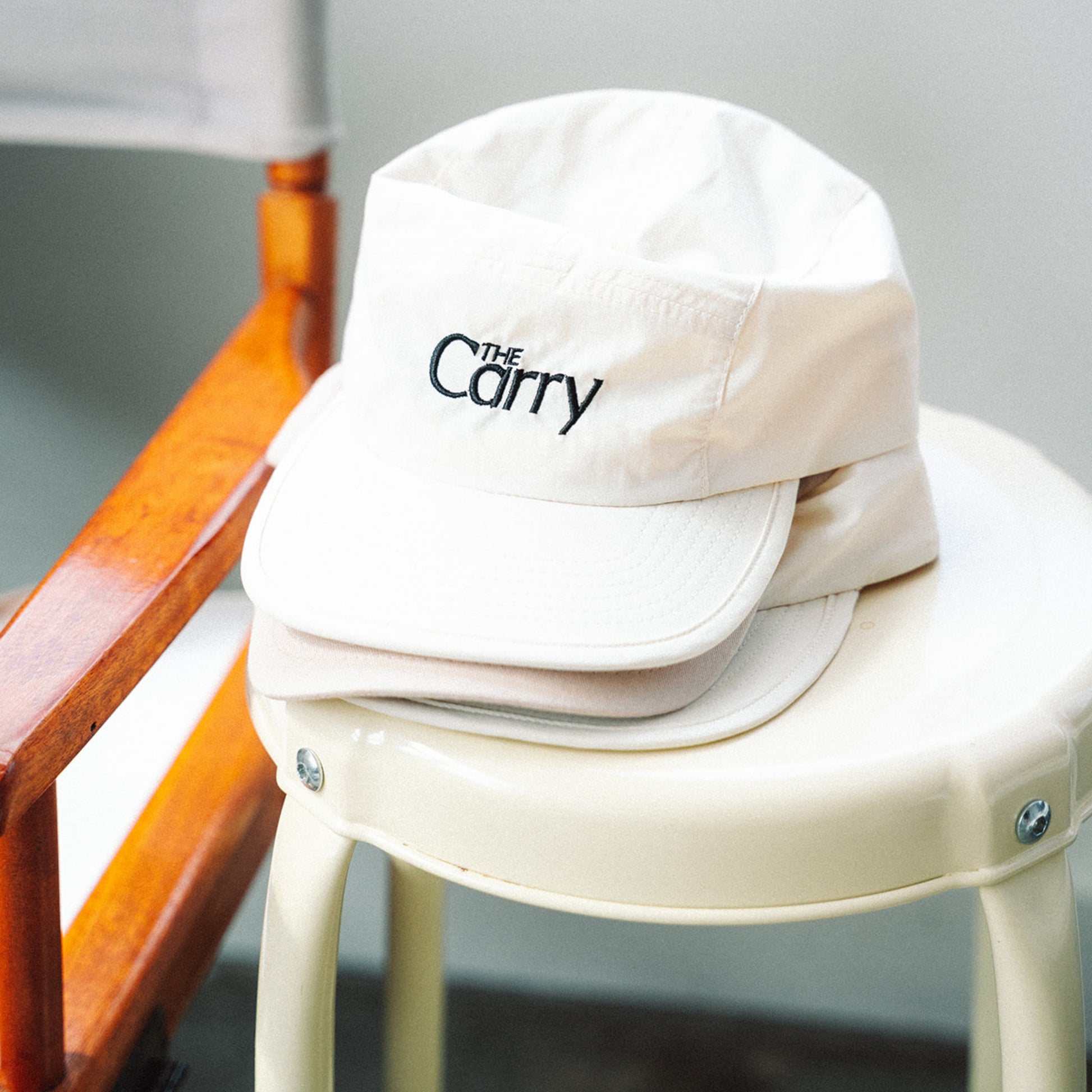 White cap with 'The Carry' logo on a white stool against a gray background