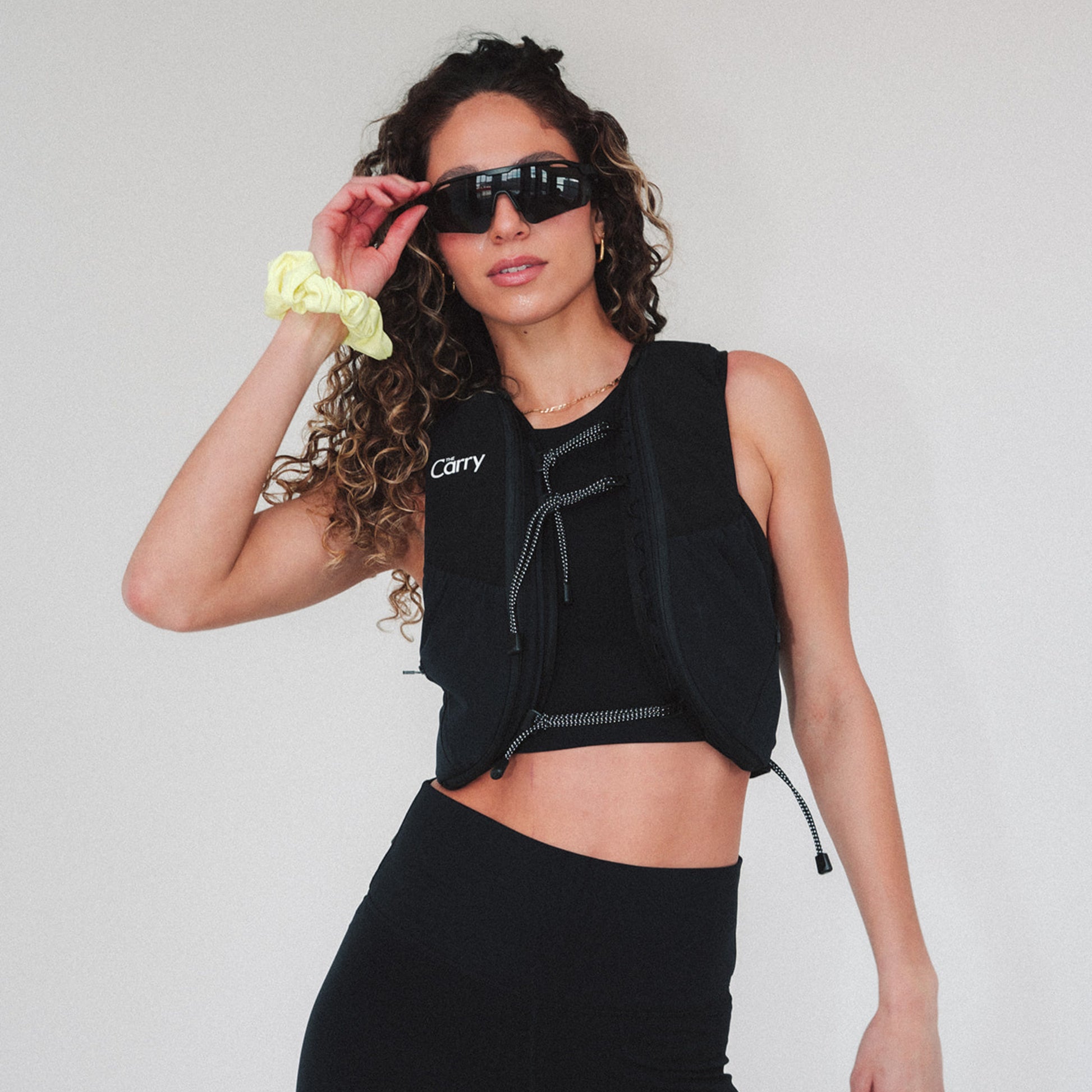 Woman wearing The Carry weighted vest in black against a plain background