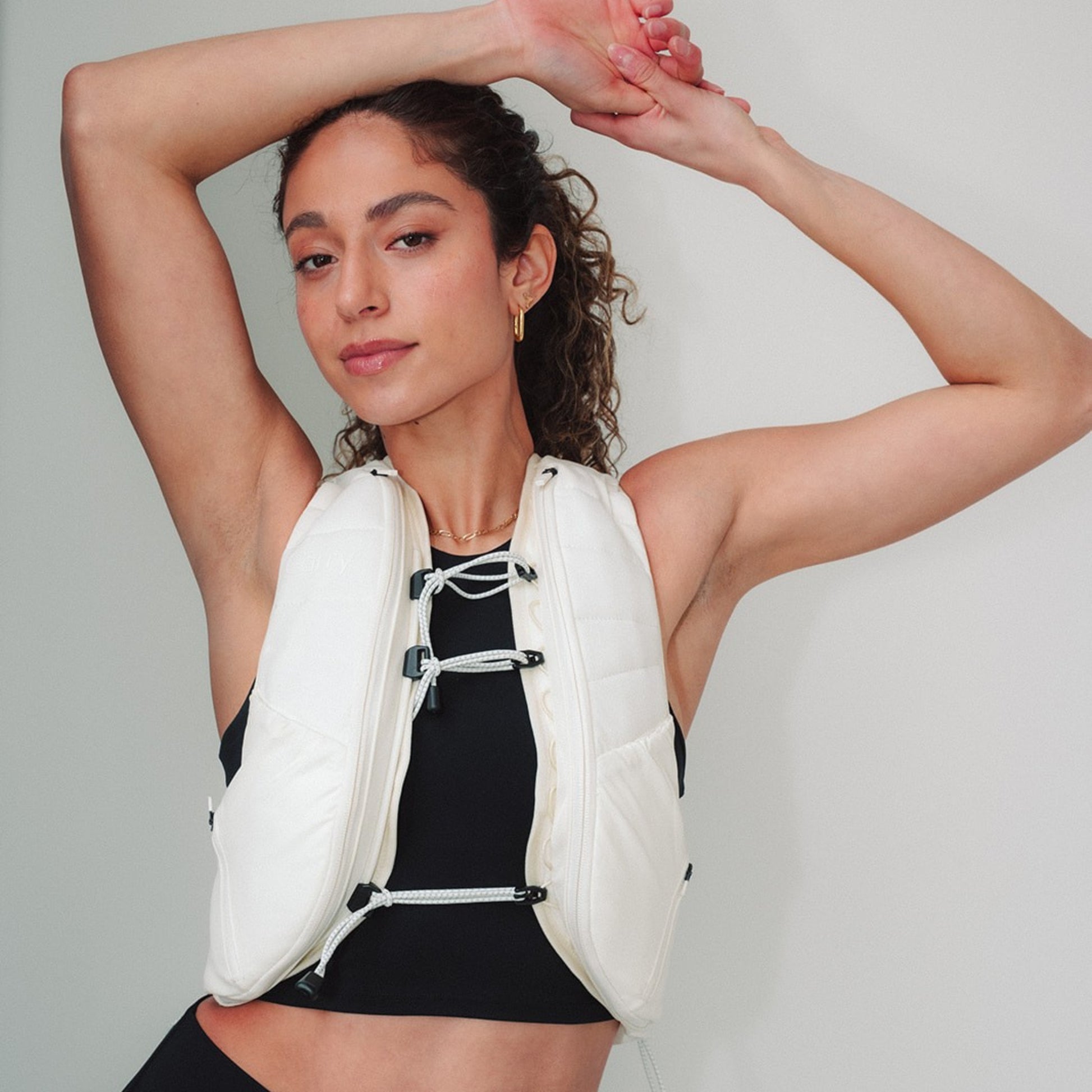 Woman wearing The Carry weighted vest in cream against a plain background
