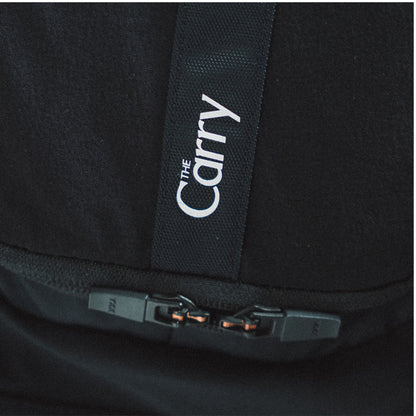 The Carry Vest shell in black, zoomed back pocket zippers and branding
