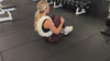 Demonstrating weighted workouts: weighted modified v-up in The Carry weighted vest